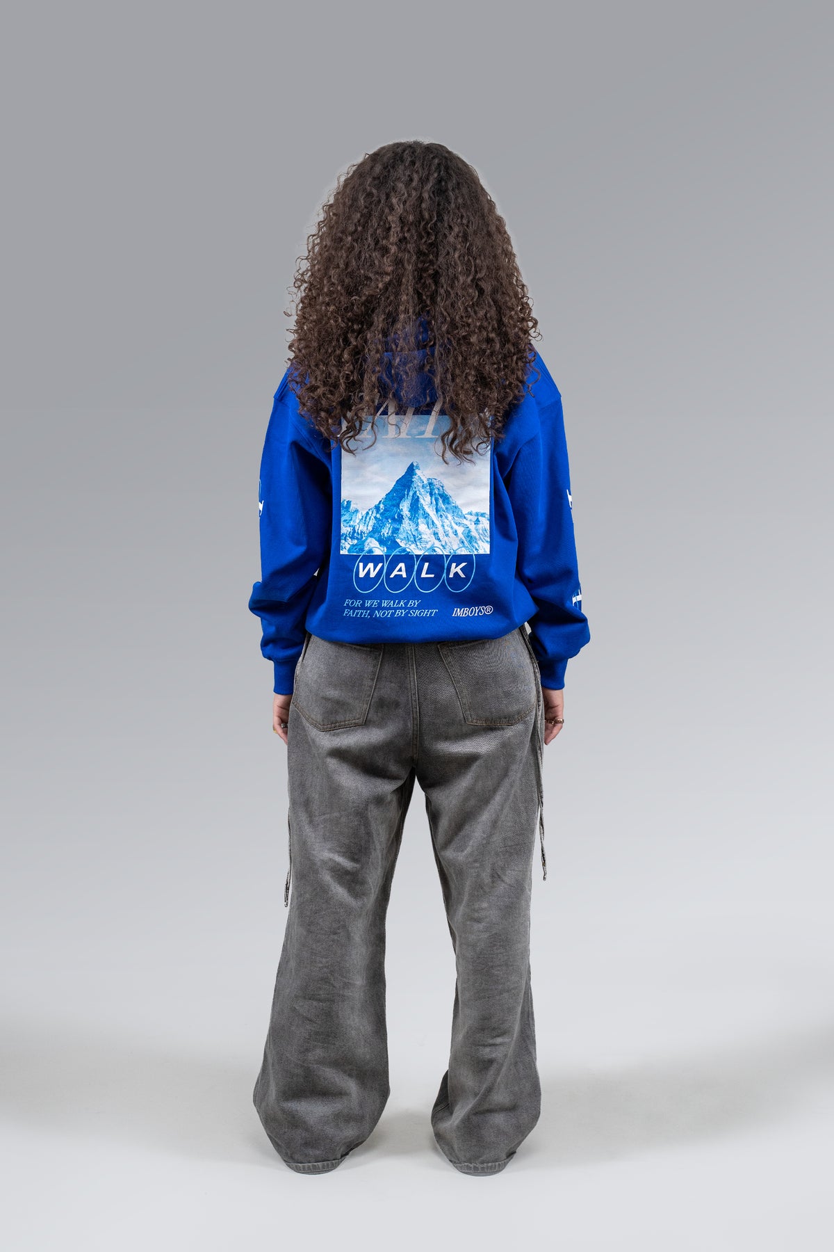 Female model wearing Blue Faith Walk Hoodie, back view