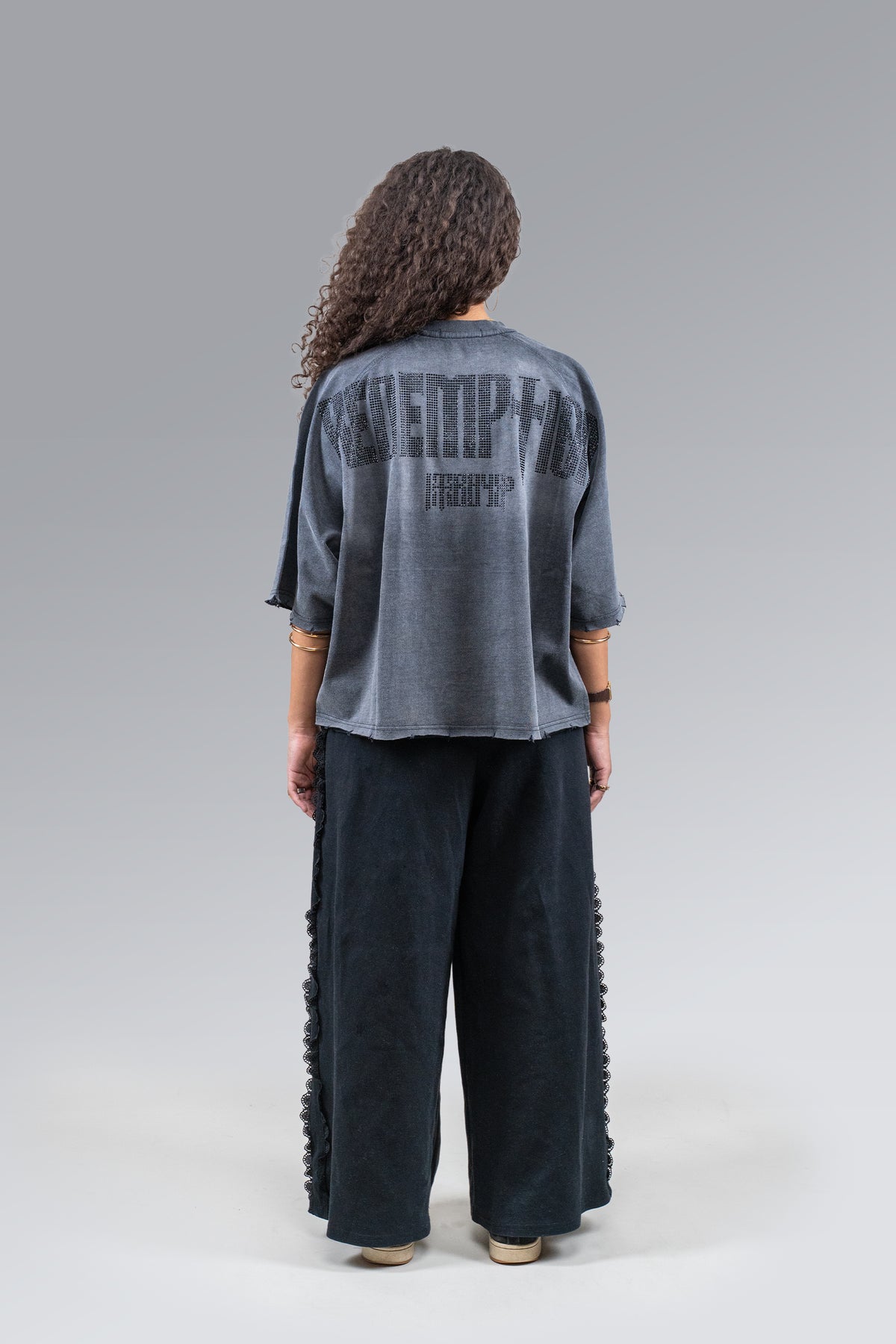 Female model wearing Black Rhinestone Tee, back view