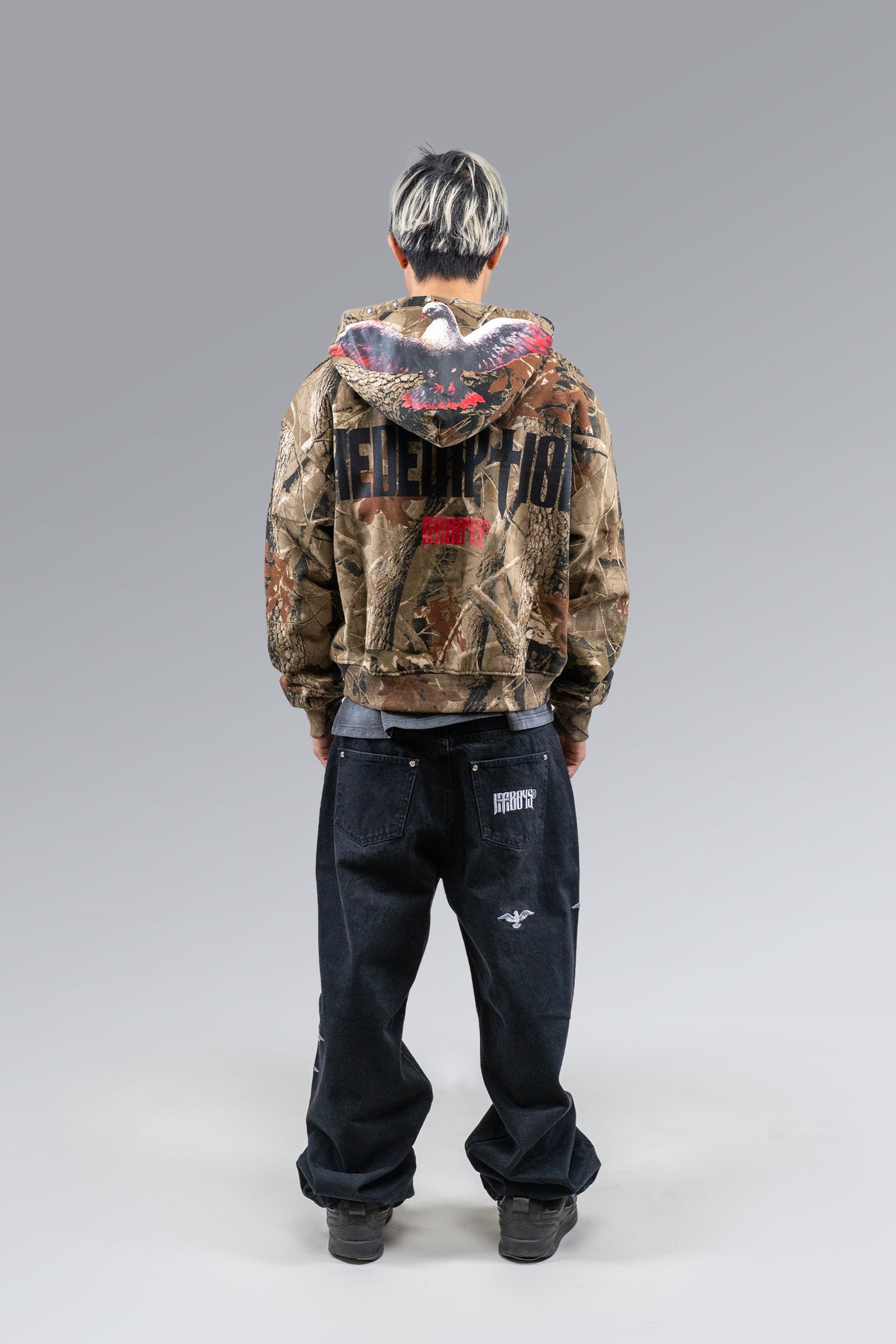 Male model wearing Redemption Camo Zip Hoodie, back view