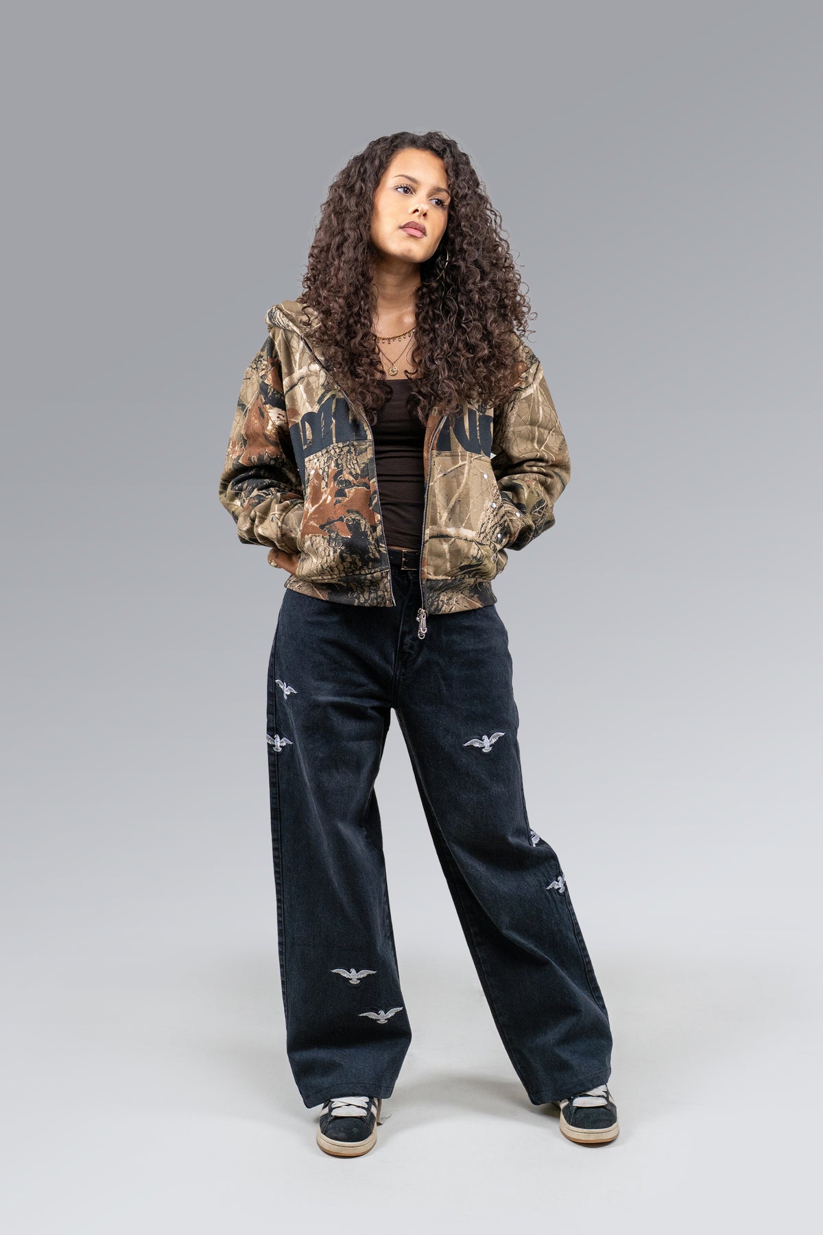 Female model wearing Redemption Camo Zip Hoodie, posed front view
